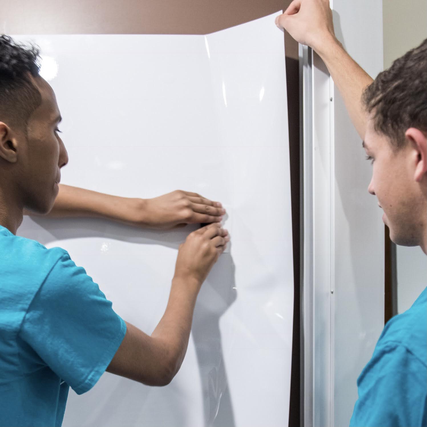 Two Think Board specialists resurfacing a whiteboard